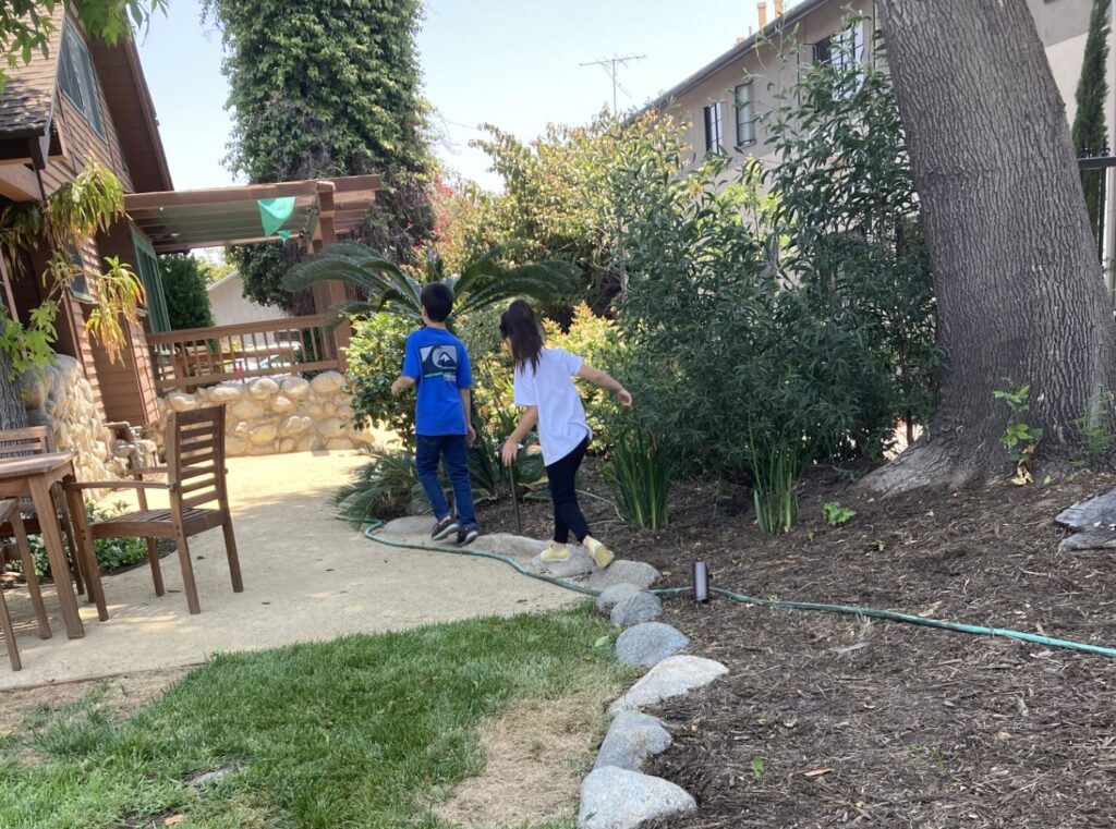 Two Academy students walking along a rock garden at IEA Learning Center